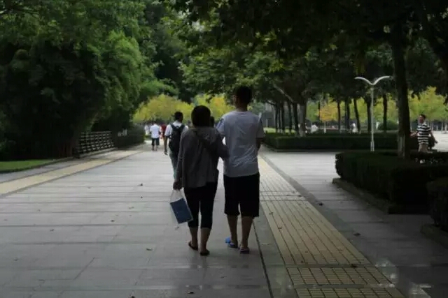 我已长大,挽着母亲的手让她不要担心我的大学生活。